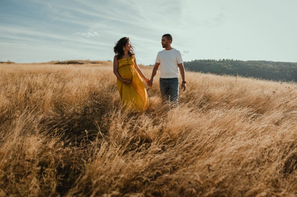 photographe grossesse saint etienne femme enceinte avec robe jaune tenant la main a son mari photographe grossesse saint etienne femme enceinte avec robe tenant la main a son mari