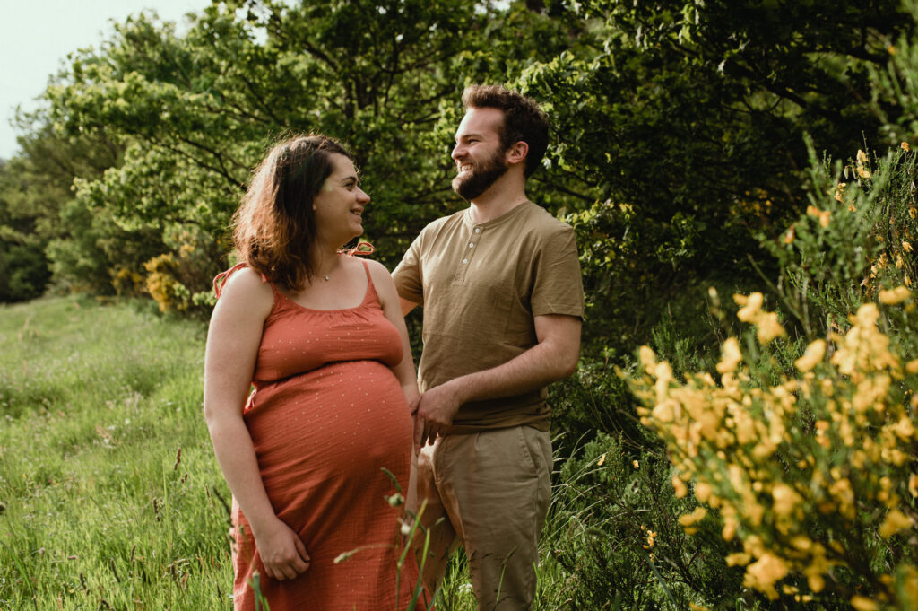 photographe grossesse saint etienne femme enceinte en robe rouge riant dans une foret photographe grossesse saint etienne femme enceinte en robe riant dans une foret