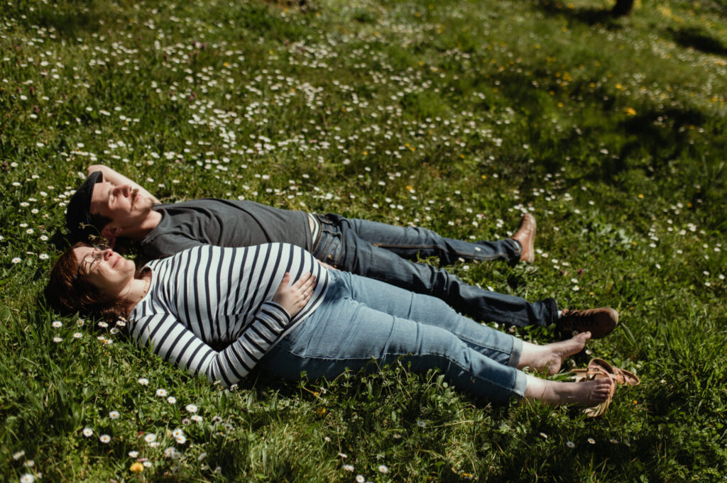 photographe grossesse saint etienne en exterieur couple allongé dans l’herbe photographe grossesse saint etienne en exterieur couple dans l'herbe